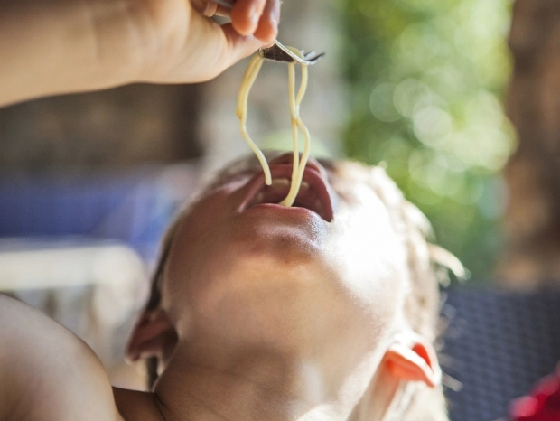 dziecko jedzące długi makaron